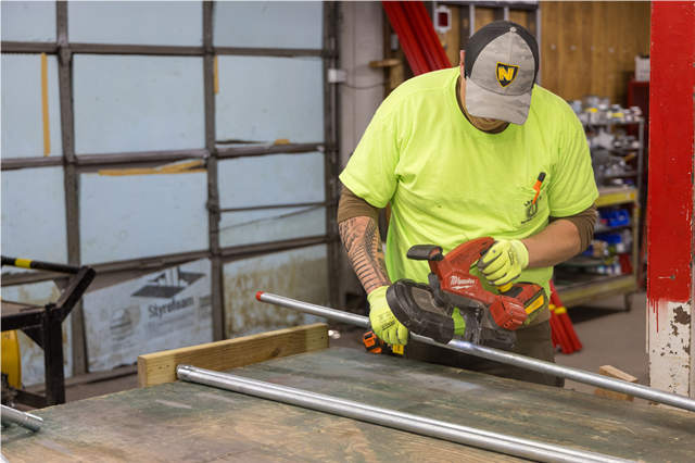 A Nelson Electric employee working with conduit pipe in the company's shop